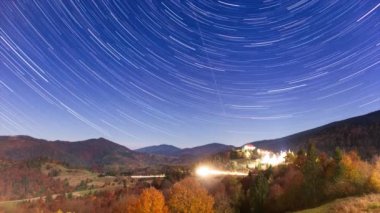 Gece gökyüzünde hareket eden yıldızların zaman çizelgesi. Samanyolu Galaksisi yaz mevsiminde dağ sırasının üzerinde döner. Yüksek kaliteli zaman dilimi.