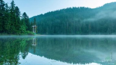 Güzel doğa ve bereketli yeşil ormanlar ve Karpatlar 'ın incisinin etrafındaki bitki örtüsüyle harika bir manzara - Synevyr Gölü. Ukrayna 'daki Karpatlar. Büyük fırtınaların üzerinde mistik bir sis var. Yüksek