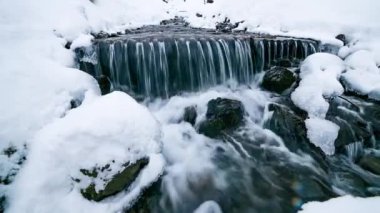 Dağlardaki buz ve kar arasında nehir suyu akar, doğal saf saf su videosu. Yükseklik kalitesi video.