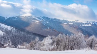 Yüksek Dağlar Tepeleri 'nin Manzaralı Hava Görüntüsü. Güneşli Kış Günü 'nde destansı manzara. Blue Sky, Fog ve Snow 'la hızlandırılmış video. Ukrayna 'daki Karpat Dağı' nın 4K Arka plan Çekimi.