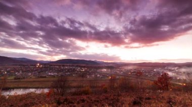 Ara sıra bulutlu mavi gökyüzüne karşı bir dağ vadisindeki köy evlerinin hava manzarası. Yeşil ormanlarla kaplı yüksek tepelerin arasına kurulmuş bir dağ köyü. Yüksek kaliteli zaman dilimi.