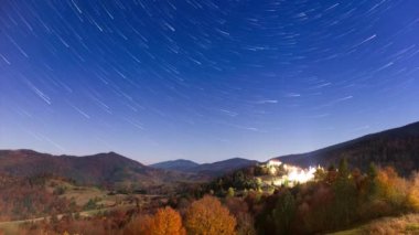 Gece gökyüzünde hareket eden yıldızların zaman çizelgesi. Samanyolu Galaksisi yaz mevsiminde dağ sırasının üzerinde döner. Yüksek kaliteli zaman dilimi.