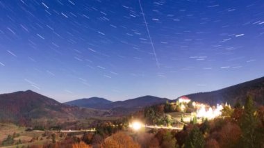 Gece gökyüzünde hareket eden yıldızların zaman çizelgesi. Samanyolu Galaksisi yaz mevsiminde dağ sırasının üzerinde döner. Yüksek kaliteli zaman dilimi.