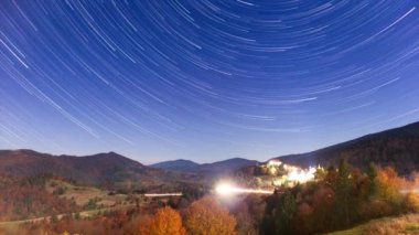 Gece gökyüzünde hareket eden yıldızların zaman çizelgesi. Samanyolu Galaksisi yaz mevsiminde dağ sırasının üzerinde döner. Yüksek kaliteli zaman dilimi.