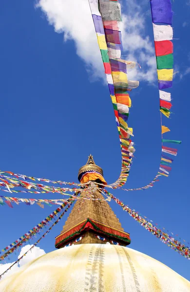 Stupa z oczy Buddy i flagi modlitewne na tle jasnego nieba — Zdjęcie stockowe