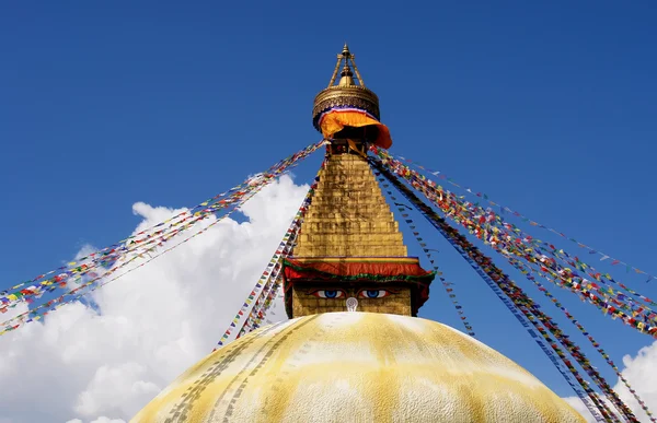 Stupa avec des yeux de bouddha et des drapeaux de prière sur fond bleu ciel clair — Photo