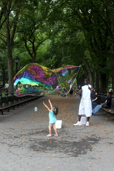 Unidentified performer and kids play with soap bubbles at Centra — Stock Photo, Image