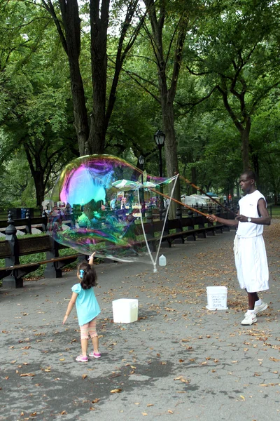 Unidentified performer and kids play with soap bubbles at Centra — Stock Photo, Image