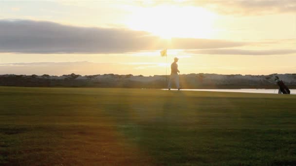 Golfer silhouet spelen bij avondschemering in algarve — Stockvideo