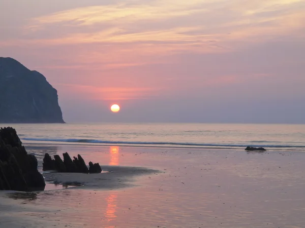 Sunset over the sea on the beach in vidiago, — Stock Photo, Image