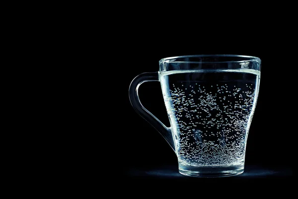 Glass of water with bubbles on black background — Stock Photo, Image