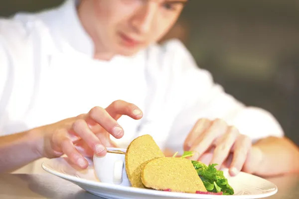 Primer plano del chef añadiendo un toque final a su plato — Foto de Stock
