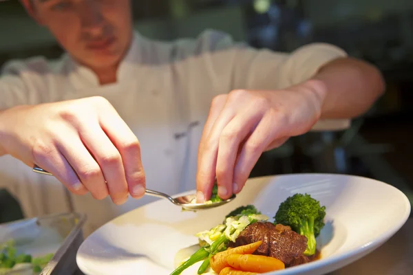 Primer plano del chef añadiendo un toque final a su plato — Foto de Stock