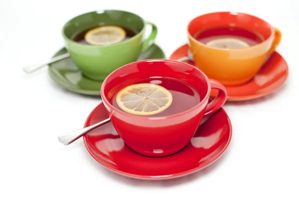 Colored tea cups with tea and lemon — Stock Photo, Image