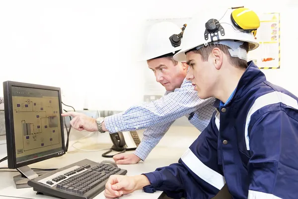 Engenheiros seniores e juniores discutindo o trabalho em conjunto no escritório — Fotografia de Stock