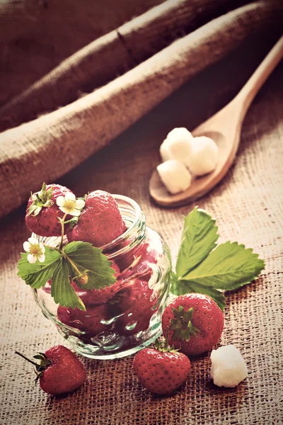 Red strawberries in glass jar on sackcloth — Stock Photo, Image