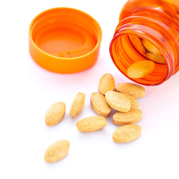 Closeup of orange pills and pill bottle — Stock Photo, Image