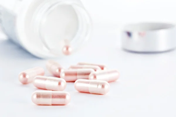 Closeup of pink pills and pill bottle — Stock Photo, Image