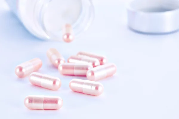 Closeup of pink pills and pill bottle — Stock Photo, Image