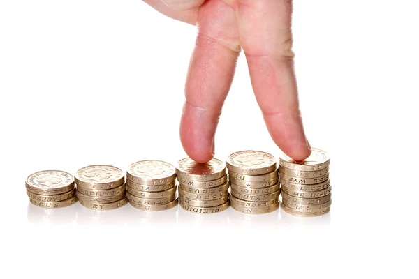 Fingers walking up on stacks of one pound coins — Stock Photo, Image