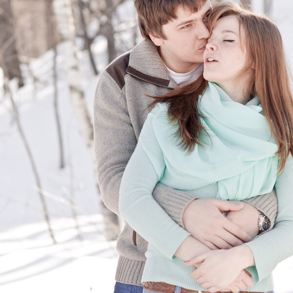 Outdoor happy couple in love, waiting for spring in cold weather