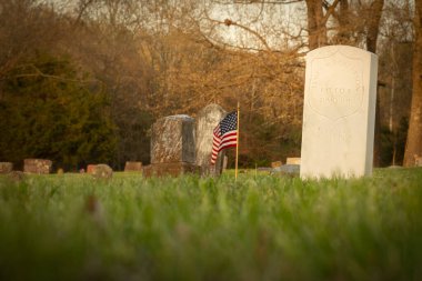 Bayrağı olan beyaz bir mezar taşı.