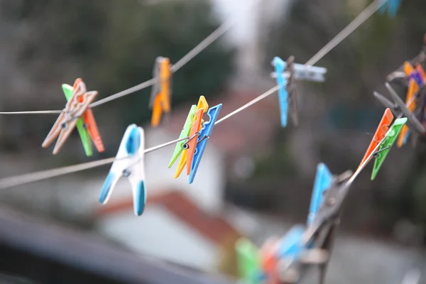 Wäscheklammern aus Holz und Kunststoff, die im Freien an einem Seil befestigt sind — Stockfoto