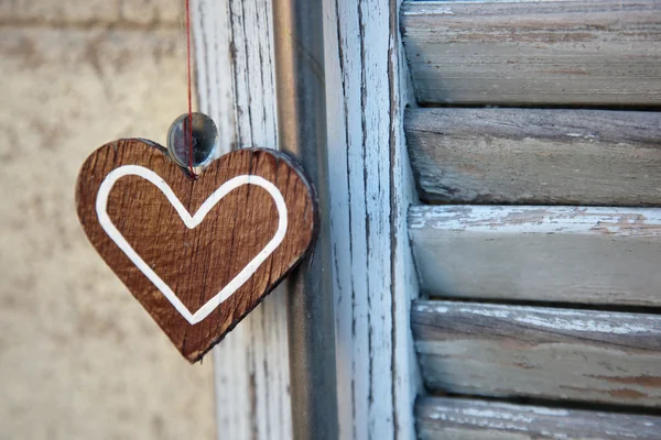 Artefacto en forma de corazón, sobre el fondo de persianas de madera —  Fotos de Stock