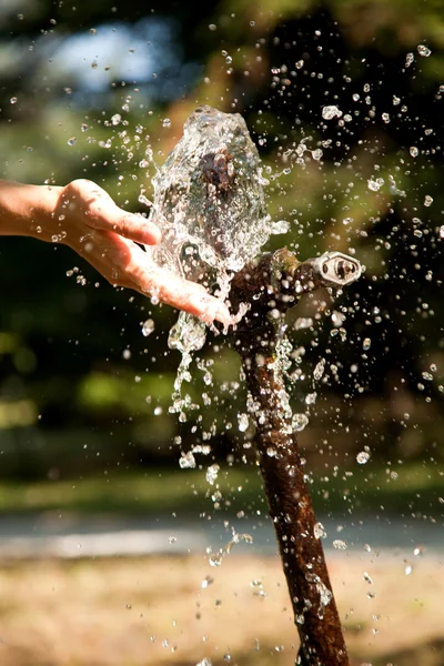 hand in the stream of water in soft focus