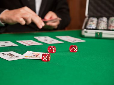 Kırmızı zar ve masada bir oyun kartı