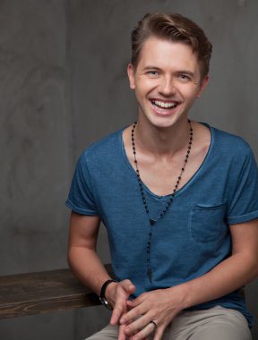 oturma ve gülerek mutlu bir genç adam