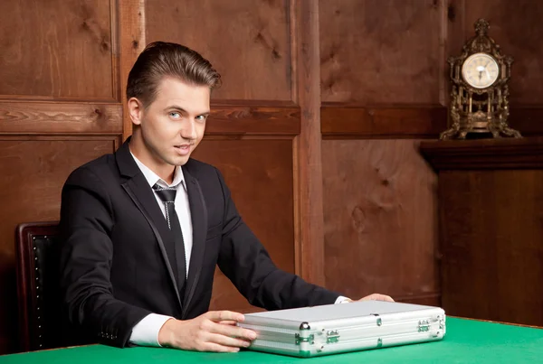 A young man with a suitcase in retro interior — Stock Photo, Image