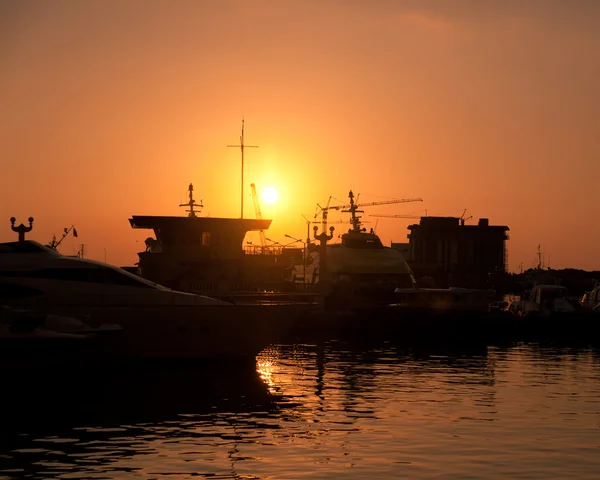 Ships at sunset in the sea port Royalty Free Stock Photos