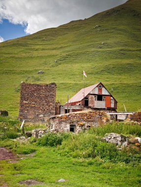 dağlarda Gürcü bayrağı ile ev