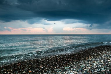 Deniz kıyısında ve dramatik bulutlar