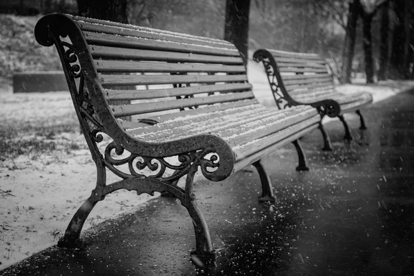 Bank im Winter und fallendem Schnee, schwarz-weiß — Stockfoto