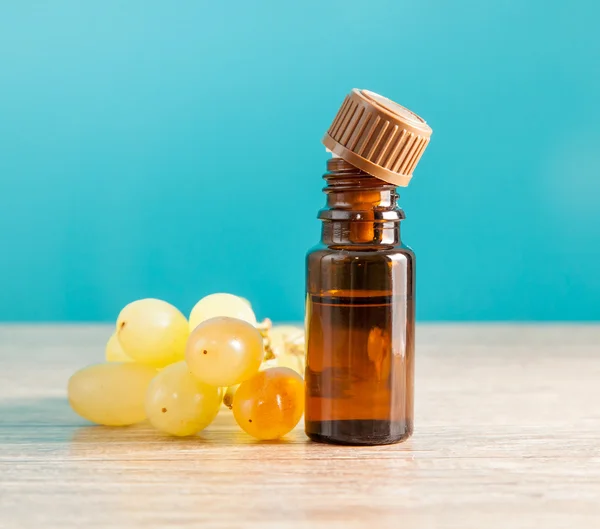 Aromatic oil and grapes — Stock Photo, Image