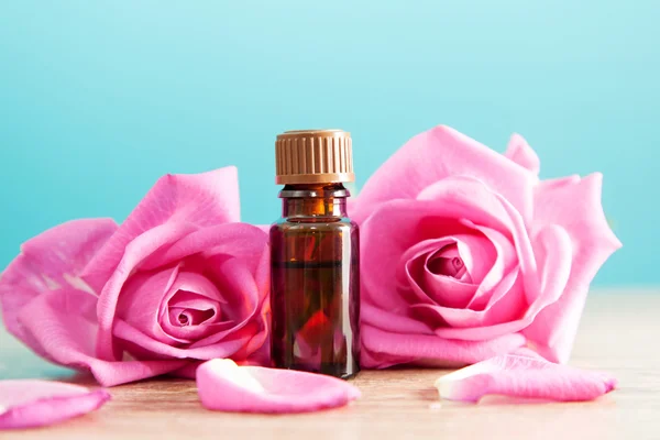 Bouteille avec huile aromatique et rose rose — Photo