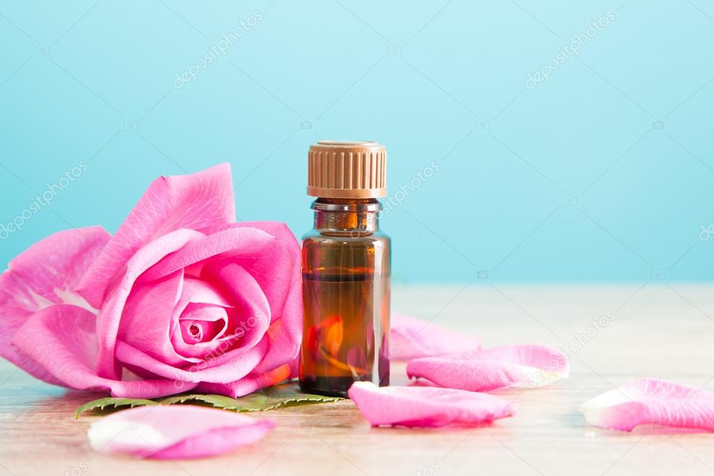 Bottle with aromatic oil and pink rose