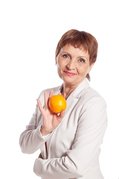 Attractive woman 50 with orange in hand — Stock Photo, Image