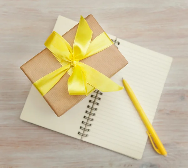 Box with a gift and a notebook — Stock Photo, Image