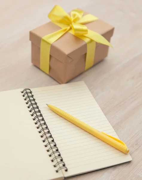 Caja con un regalo y un cuaderno — Foto de Stock