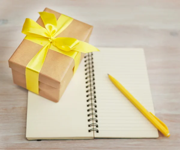 Caja con un regalo y un cuaderno — Foto de Stock