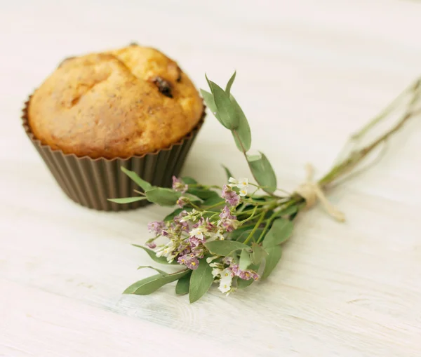 Homemade muffin and a bouquet of wild flowers — Stock Photo, Image