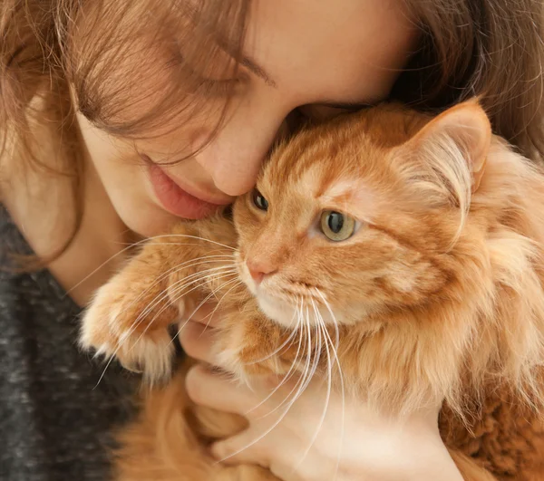 Portrait of beautiful young woman 20 years with a fluffy red ca — Stock Photo, Image