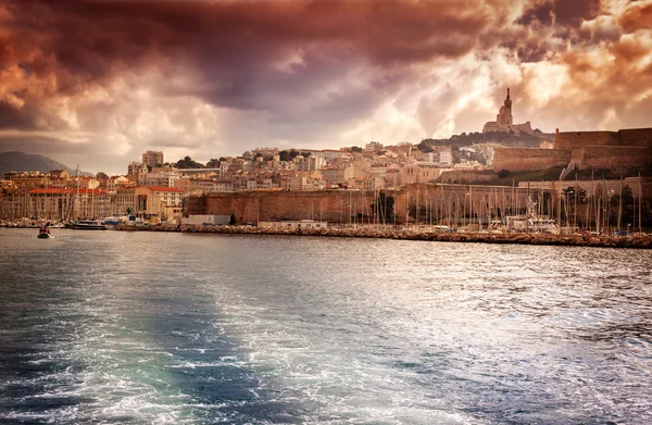 Вид на місто і морський порт на тлі драматичних сонця — стокове фото