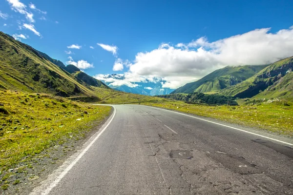 Road in the mountains, bright summer, in soft focus — Stock Photo, Image