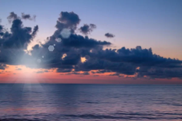 Puesta de sol borrosa de colores brillantes sobre el mar, en enfoque suave — Foto de Stock