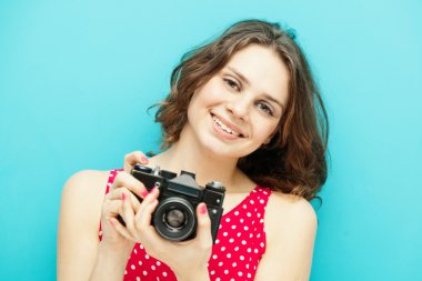 mavi bir arka plan üzerinde vintage fotoğraf makinesi ile güzel kız
