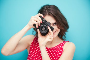 mavi bir arka plan üzerinde vintage fotoğraf makinesi ile güzel kız